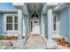 Inviting front entrance featuring decorative columns, a patterned walkway, and manicured landscaping at 7039 Woodibis Dr, New Port Richey, FL 34654