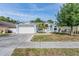 Charming single-story home with a well-maintained lawn, manicured landscaping, and a two-car garage at 7039 Woodibis Dr, New Port Richey, FL 34654
