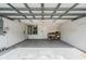 Spacious garage with white walls, water heater, storage shelving, and concrete flooring for parking at 7039 Woodibis Dr, New Port Richey, FL 34654