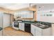 Bright kitchen with white cabinets, an oven, and a double-bowl stainless steel sink at 7039 Woodibis Dr, New Port Richey, FL 34654