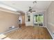 Bright living room with wood-look floors, neutral paint, and sliding glass doors to the backyard at 7039 Woodibis Dr, New Port Richey, FL 34654