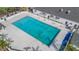 Aerial view of a community swimming pool with colorful flags and a building with AC units at 7039 Woodibis Dr, New Port Richey, FL 34654