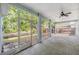 Enclosed patio featuring tiled floors, ceiling fan, and screens providing views of backyard and landscaping at 7039 Woodibis Dr, New Port Richey, FL 34654