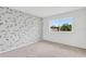 bedroom with accent wallpaper and large window for a simple yet stylish room at 7113 S Kissimmee St, Tampa, FL 33616