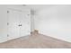 A bright empty bedroom with neutral carpet, a large closet, and a view of an open doorway at 7113 S Kissimmee St, Tampa, FL 33616