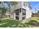 View of the back exterior showcasing the screened in porch and backyard at 7113 S Kissimmee St, Tampa, FL 33616