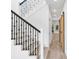 Open hallway with wood-look tile floors, iron-railed staircase and natural wood sliding barn door at 7113 S Kissimmee St, Tampa, FL 33616