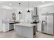 Modern kitchen with white cabinets, stainless appliances, and center island with quartz countertops at 7113 S Kissimmee St, Tampa, FL 33616