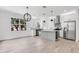 Open concept kitchen and dining with stainless appliances and neutral white color palette at 7113 S Kissimmee St, Tampa, FL 33616