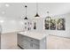 Bright and airy kitchen featuring a gray island with a white countertop and modern lighting at 7113 S Kissimmee St, Tampa, FL 33616