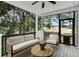 Cozy screened porch with comfortable seating and a view of the backyard at 7113 S Kissimmee St, Tampa, FL 33616