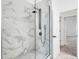 Shower with glass door, white marble tile, and black fixtures at 7113 S Kissimmee St, Tampa, FL 33616