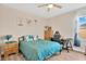 Cozy bedroom features a ceiling fan, desk and chair, and a wood dresser for storage at 7502 Sea Lilly Ct, Apollo Beach, FL 33572