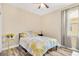 Well-lit bedroom with a ceiling fan and large window overlooking green foliage at 7502 Sea Lilly Ct, Apollo Beach, FL 33572