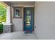 Inviting front entrance with a stylish blue door, stone accents, and a covered porch at 7502 Sea Lilly Ct, Apollo Beach, FL 33572