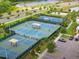 Aerial view showcasing well-maintained tennis and basketball courts surrounded by lush landscaping at 7502 Sea Lilly Ct, Apollo Beach, FL 33572