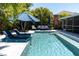Backyard view showcasing a pool with loungers, umbrellas, and comfortable outdoor seating for relaxation and entertainment at 865 Live Oak Ne Ter, St Petersburg, FL 33703