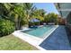 Backyard oasis features a modern pool with lush tropical landscaping and outdoor seating for relaxation at 865 Live Oak Ne Ter, St Petersburg, FL 33703