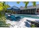 Lounge by this pool in this screened backyard, featuring sun loungers and cozy seating under a large umbrella at 865 Live Oak Ne Ter, St Petersburg, FL 33703