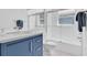 Bathroom featuring blue vanity, modern fixtures, glass shower door, and neutral tones for a fresh, clean feel at 865 Live Oak Ne Ter, St Petersburg, FL 33703