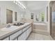 Bright bathroom featuring double sinks, tub, shower and large windows at 865 Live Oak Ne Ter, St Petersburg, FL 33703