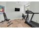 Home gym with travertine floors, exercise equipment, and a wall mounted TV at 865 Live Oak Ne Ter, St Petersburg, FL 33703