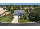 Charming single-story home with manicured lawn, lush landscaping, and a paved driveway leading to an attached garage at 865 Live Oak Ne Ter, St Petersburg, FL 33703