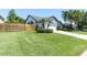 Well-manicured lawn leading to a charming home featuring a wooden fence and lush palm trees at 865 Live Oak Ne Ter, St Petersburg, FL 33703