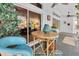 Covered outdoor patio with blue chairs and bamboo table, leading to bright interiors through sliding glass doors at 865 Live Oak Ne Ter, St Petersburg, FL 33703