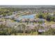 An aerial view of a residential community featuring a pond, mature trees, and landscaped yards at 9823 Rolling Cir, San Antonio, FL 33576