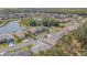An aerial view of a residential area with a pond, lush greenery, and well-maintained homes at 9823 Rolling Cir, San Antonio, FL 33576
