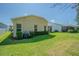 A spacious backyard with healthy lawn, bushes along the back of the home, and blue skies above at 9823 Rolling Cir, San Antonio, FL 33576