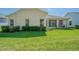 Well-maintained backyard with lush green grass, trimmed bushes, and a view of the house's exterior at 9823 Rolling Cir, San Antonio, FL 33576