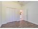 This is a bedroom with wood-look flooring and a closet and an open door leads to the kitchen at 9823 Rolling Cir, San Antonio, FL 33576