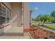 A charming front entrance with a tiled porch and meticulously landscaped flower beds, creating a delightful curb appeal at 9823 Rolling Cir, San Antonio, FL 33576