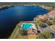 Scenic aerial view of community pool, clubhouse, and lakefront property at 9828 Lake Chase Island Way # 0, Tampa, FL 33626