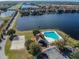 Aerial view featuring a volleyball court, a pool, a parking lot, and a lake at 9828 Lake Chase Island Way # 0, Tampa, FL 33626