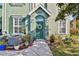 Charming home featuring a vibrant green front door with decorative wreath and lovely potted plants lining the walkway at 9828 Lake Chase Island Way # 0, Tampa, FL 33626