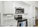 Bright kitchen with white cabinets, stainless steel microwave and range, and stylish countertops at 9828 Lake Chase Island Way # 0, Tampa, FL 33626