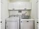 Laundry room with white cabinets over a white washer and dryer unit at 9828 Lake Chase Island Way # 0, Tampa, FL 33626