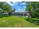 Wide backyard with screened-in pool enclosure, mature trees, and ample green space at 1007 Morfield Ln, Brandon, FL 33511