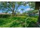 Expansive backyard with lush green lawn, mature trees, and a play area for  at 1007 Morfield Ln, Brandon, FL 33511