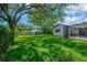 Large backyard featuring a play area, lush grass, and a screened-in pool enclosure at 1007 Morfield Ln, Brandon, FL 33511