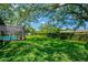 Large grassy backyard featuring a pool, privacy fence, and plenty of space for outdoor activities at 1007 Morfield Ln, Brandon, FL 33511