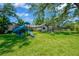 Spacious backyard featuring a playground, lush green grass, and mature trees for shade at 1007 Morfield Ln, Brandon, FL 33511