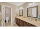 Well-lit bathroom with double sinks, dark wood cabinetry, and neutral tile flooring at 1007 Morfield Ln, Brandon, FL 33511
