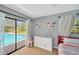 Bright bedroom featuring a pool view, dresser, and light blue walls at 1007 Morfield Ln, Brandon, FL 33511
