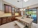 Light-filled dining area with a rustic wooden table, bench seating, and a view of the pool at 1007 Morfield Ln, Brandon, FL 33511