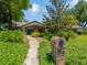 Charming single-story home featuring a well-manicured lawn, mature trees, and a welcoming walkway to a decorative front door at 1007 Morfield Ln, Brandon, FL 33511
