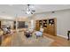 Bright living room boasts a ceiling fan, a dark wooden bookcase, and hardwood floors at 1007 Morfield Ln, Brandon, FL 33511